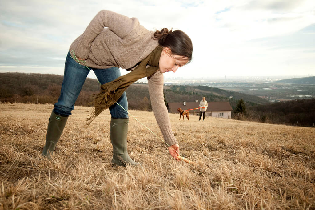 Schleppfährte Hundetraining Korneuburg. Hundetrainerin Sandra Dorfner-Rösel legt eine Schleppfährte für eine Kundin mit ihrem braunen Hund.